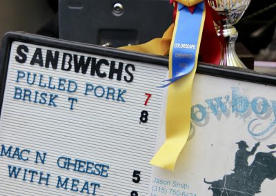 A yellow and blue ribbon hangs next to a menu detailing food options