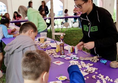A volunteer leads children in an Art Zone activity at the Colorscape Chenango Arts Festival
